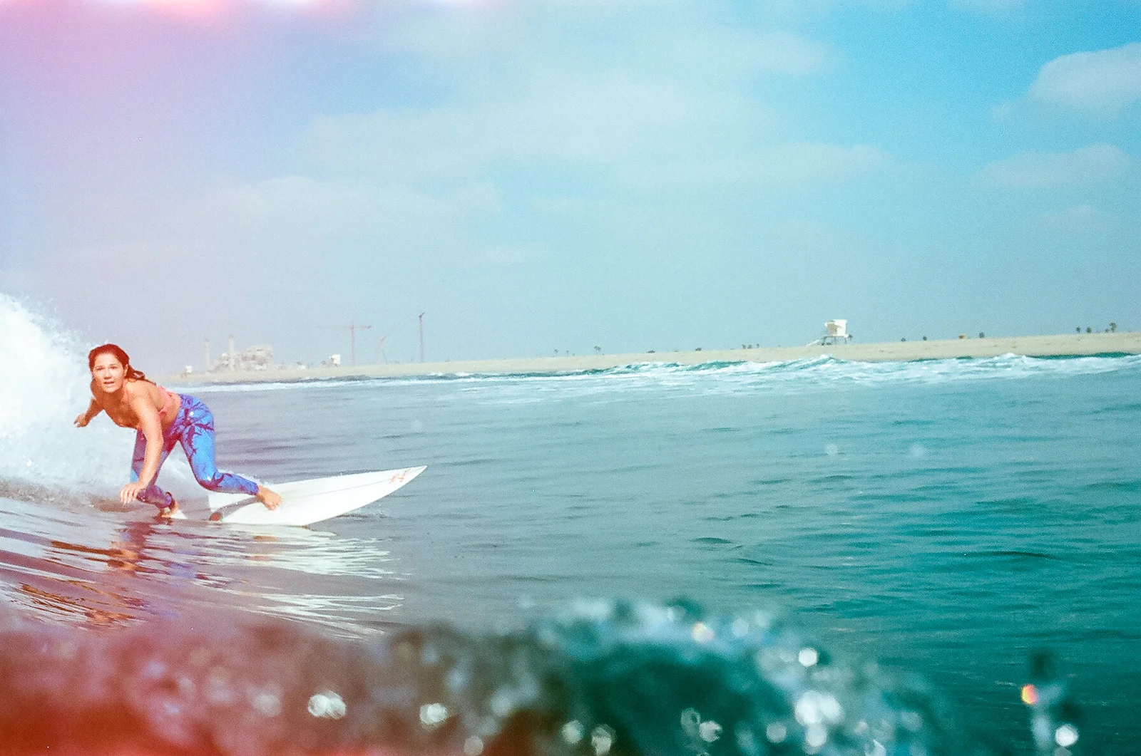 35mm color film Surfing photo shoot in the water at Huntington State Beach with girl surfer surfing for Get wise fool eco-friendly surf company