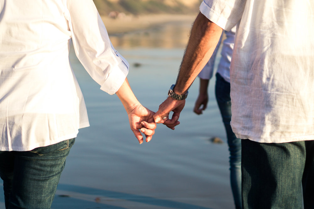  Family portraits of husband and wife walking on the beach holding hands&nbsp; at Crystal Cove Beach at Crystal Cove Beach in Newport during Golden hour 