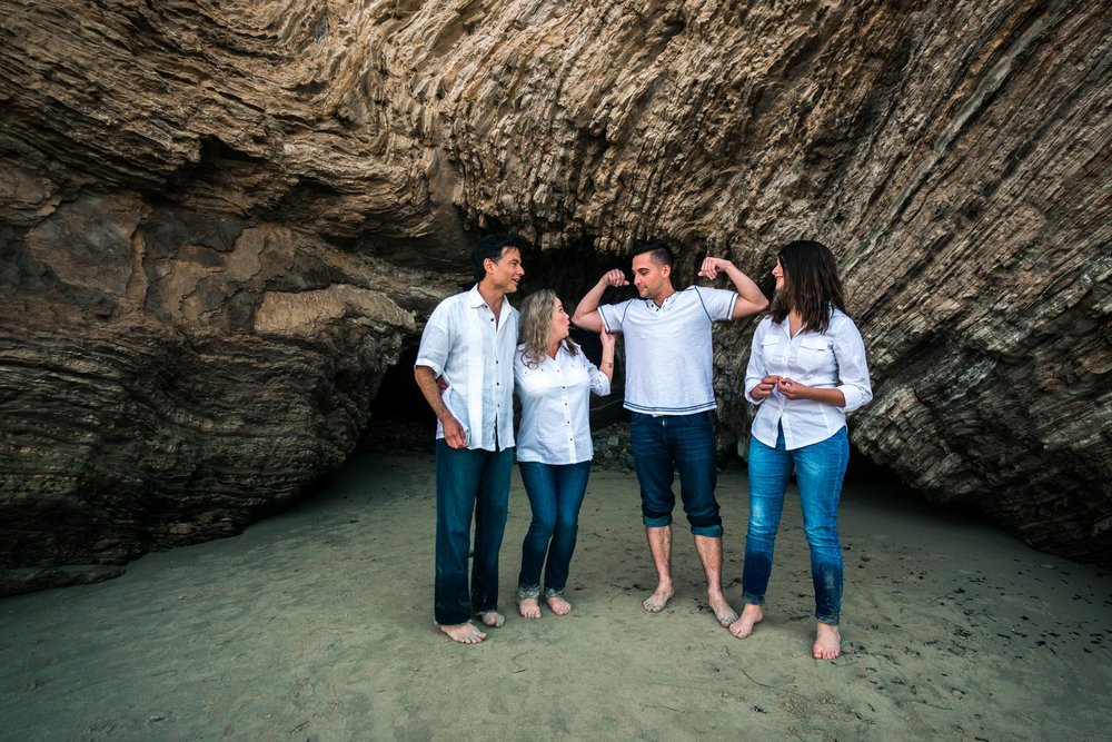 Family portraits of family posing near sea cave and cliff during Golden hour at Crystal Cove State Beach in Newport