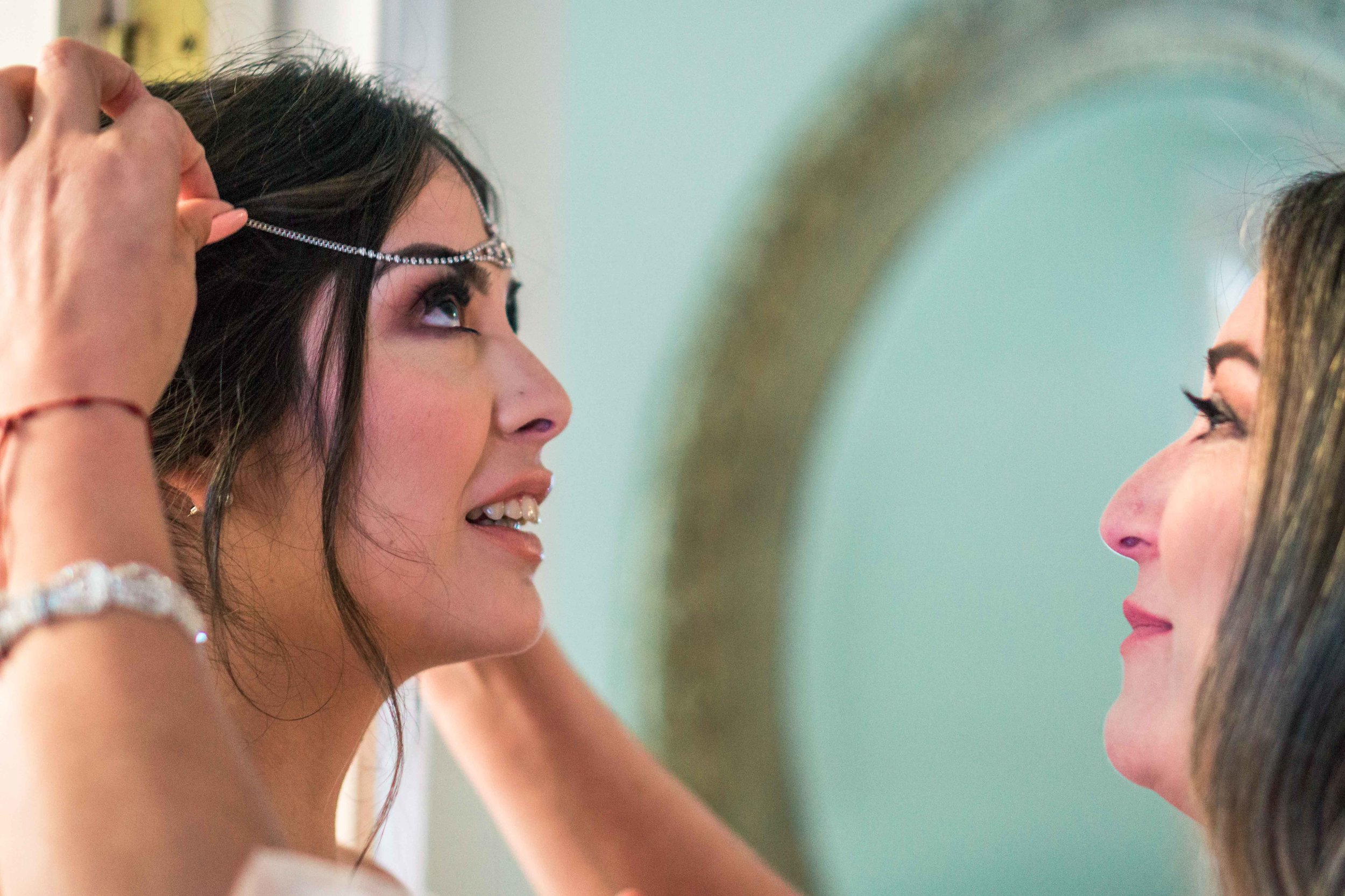 Photo of the mom helping her daughter the wedding bride put on her Head dress before her wedding on Balboa Island  in Newport Beach