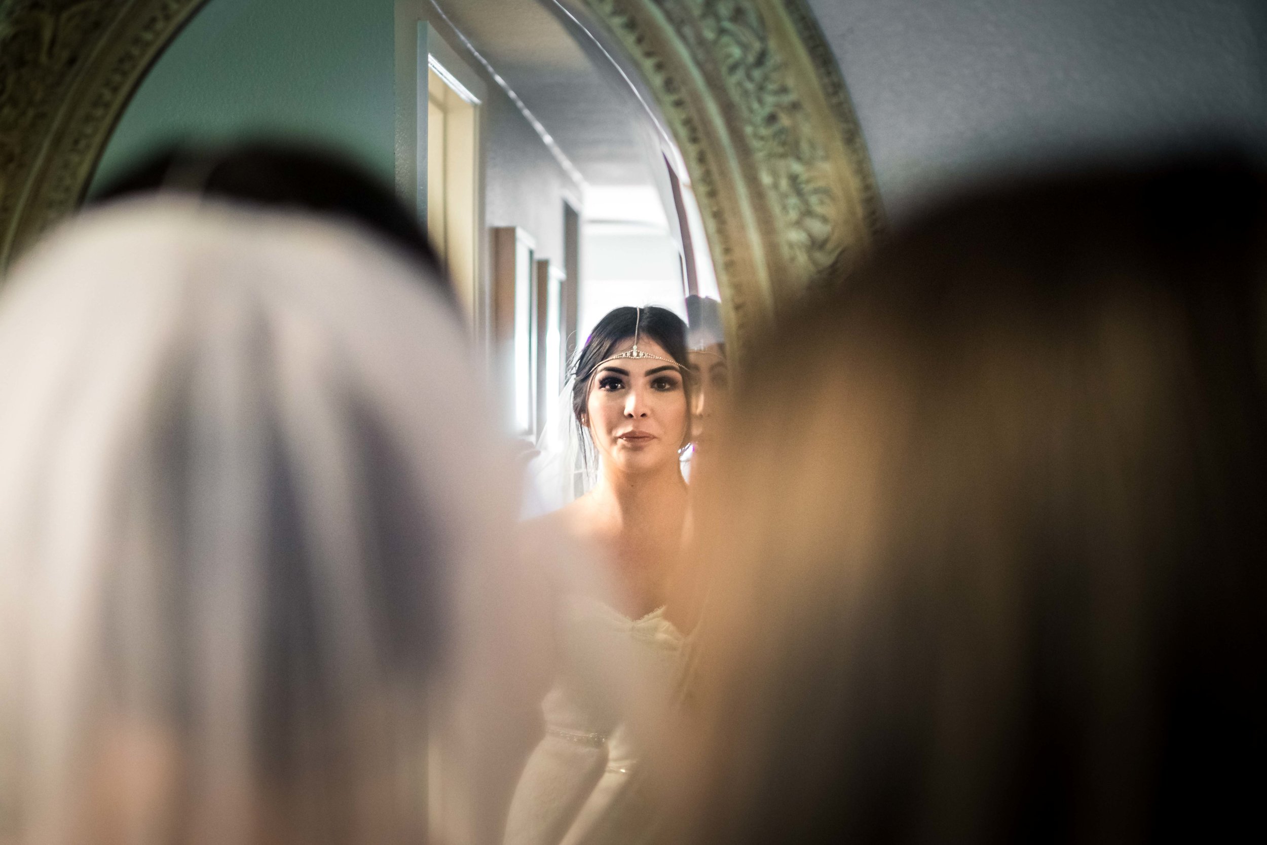 Candid wedding Photo taken of the bride with her mother looking in the mirror while she's getting ready before her wedding on Balboa Island