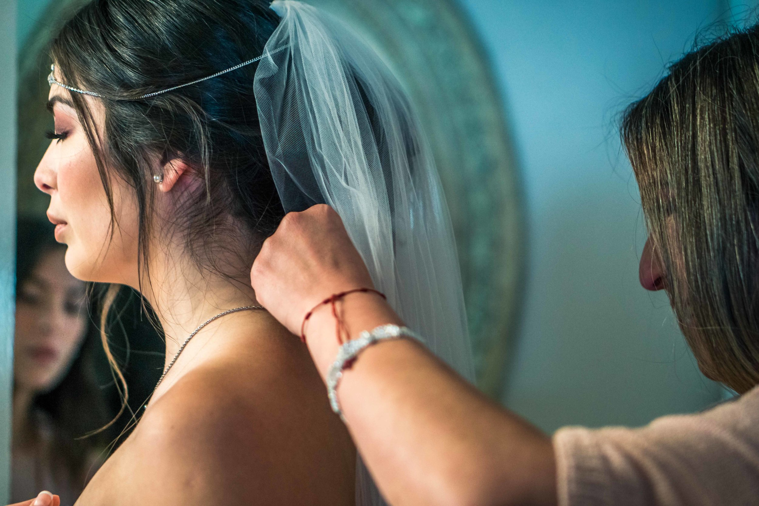 Photo journalistic wedding photo  of the Brides mom and Her sister helping her get readyJust before her wedding ceremony in Newport Beach