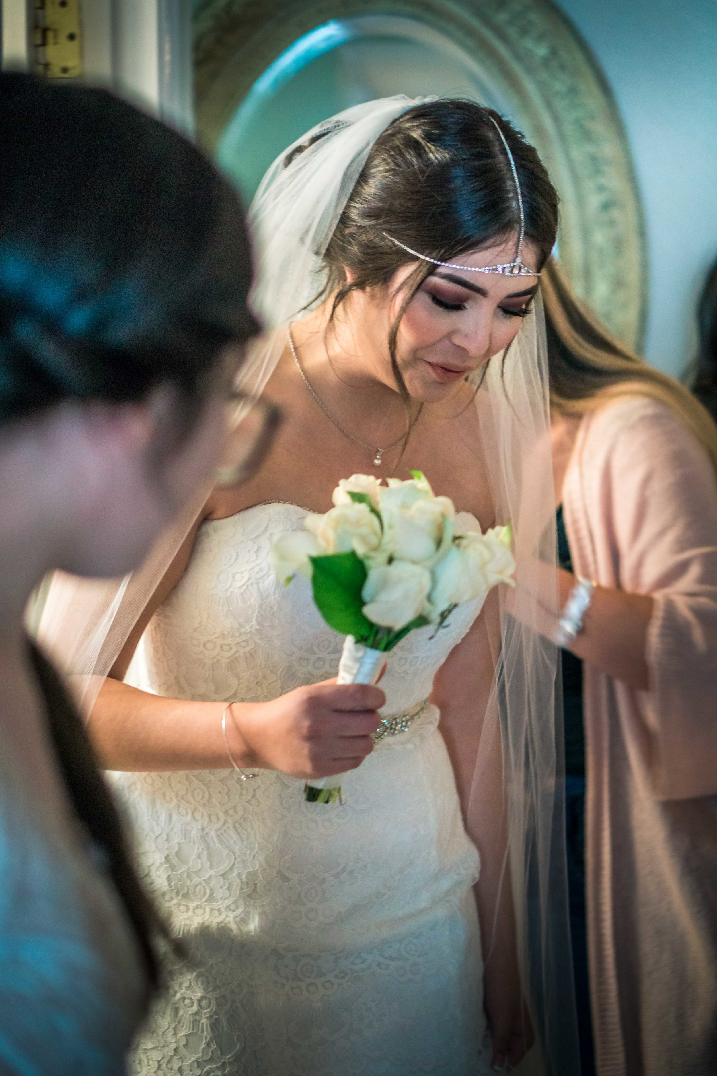 Bride with your bouquet in her wedding dress been helped by her mother and sister