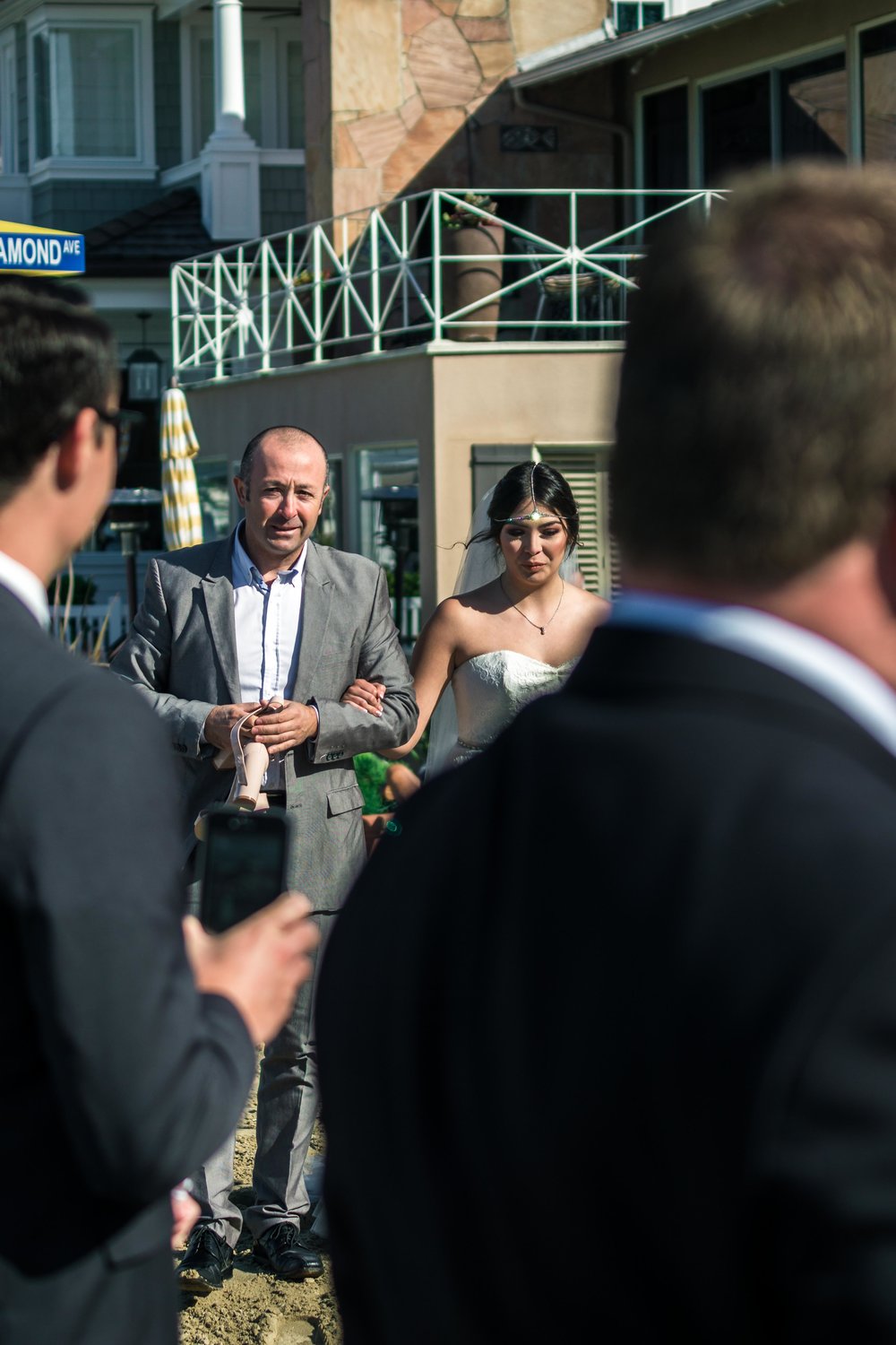 The brides father walking her down the aisle during her ceremony on Balboa Island