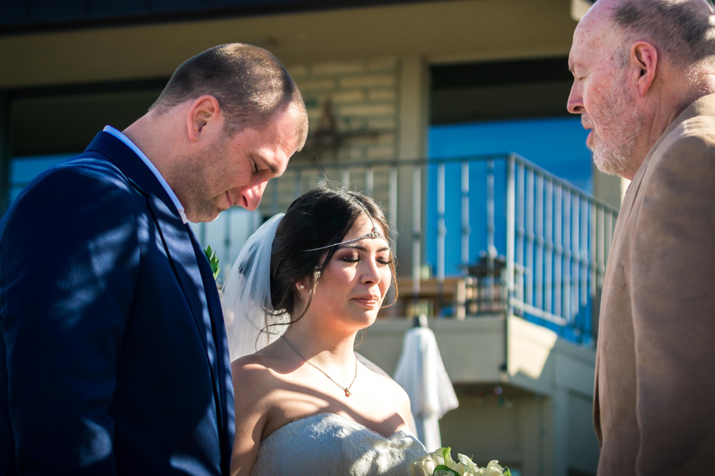 The Bride and groom praying during Their vows at wedding alter