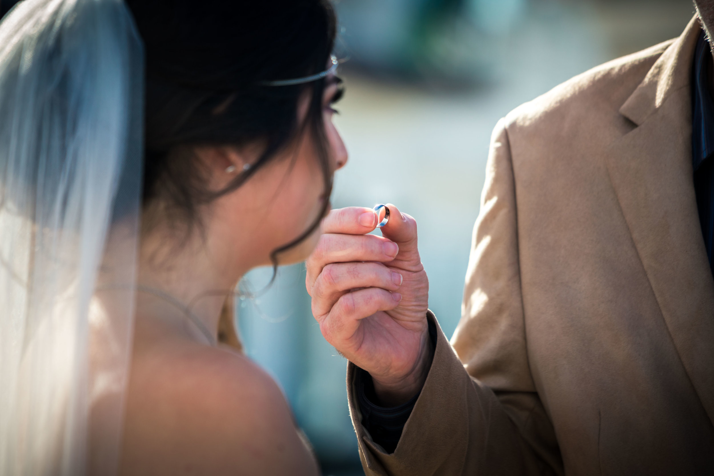 The pastor handing the wedding ring to The bride at the altar