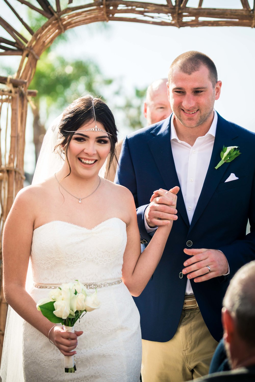 Bride and groom smiling and walking down the aisle after they're married