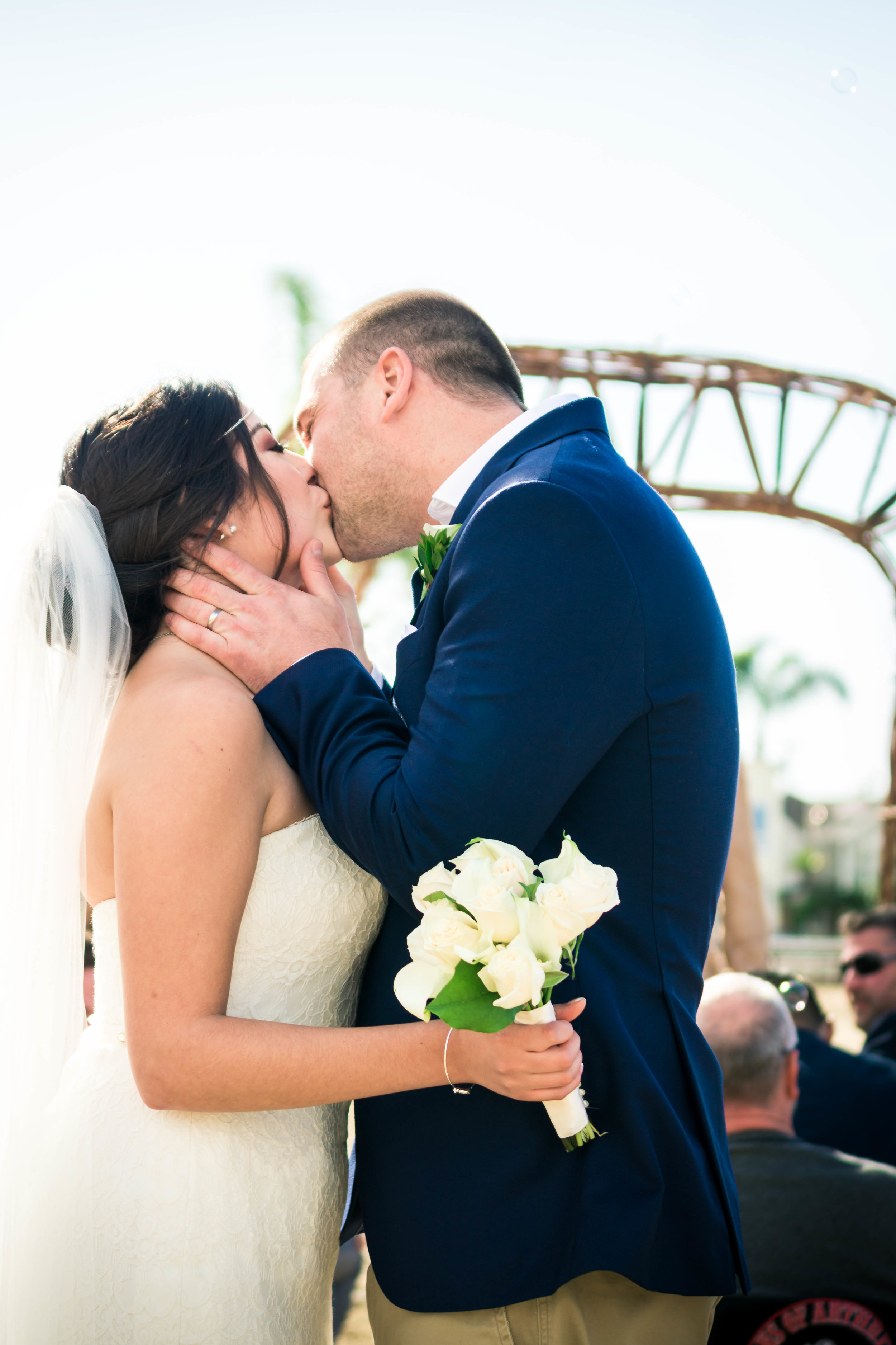 The groom passionately kissing his bride after they have been married