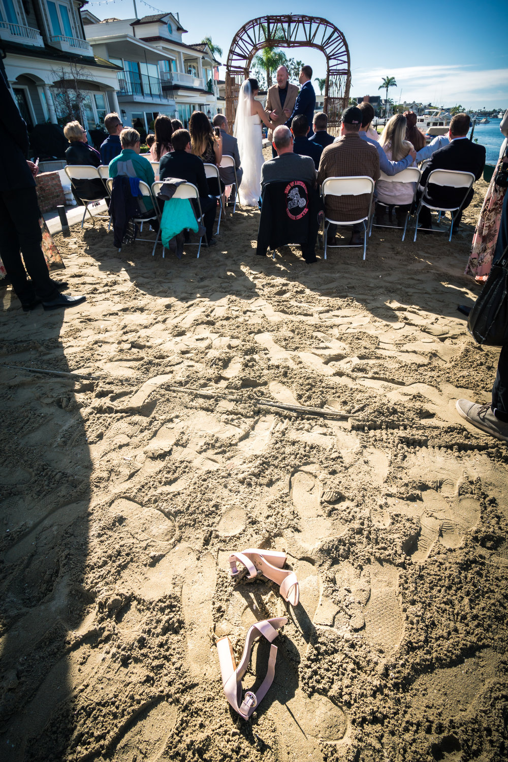 The bride shoes in the sand on the beach during the wedding ceremony on Balboa Island