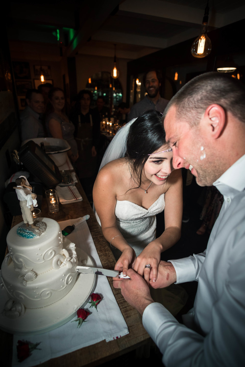 Bride and groom cutting The wedding cake And laughing