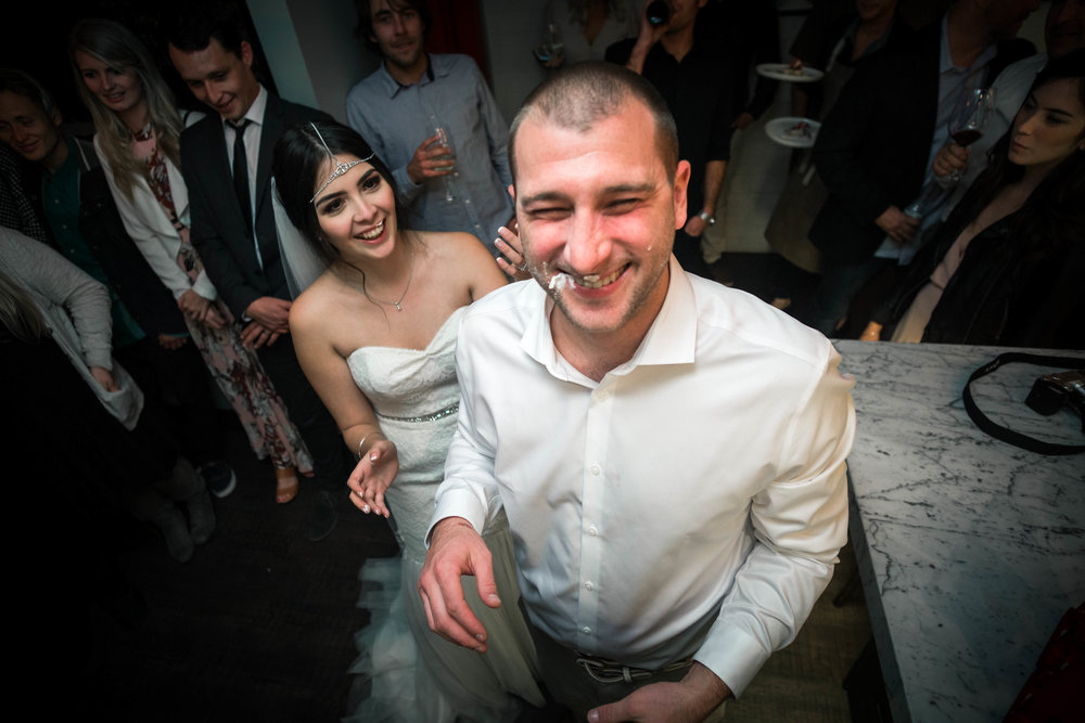 The bride and groom laughing after cutting the cake