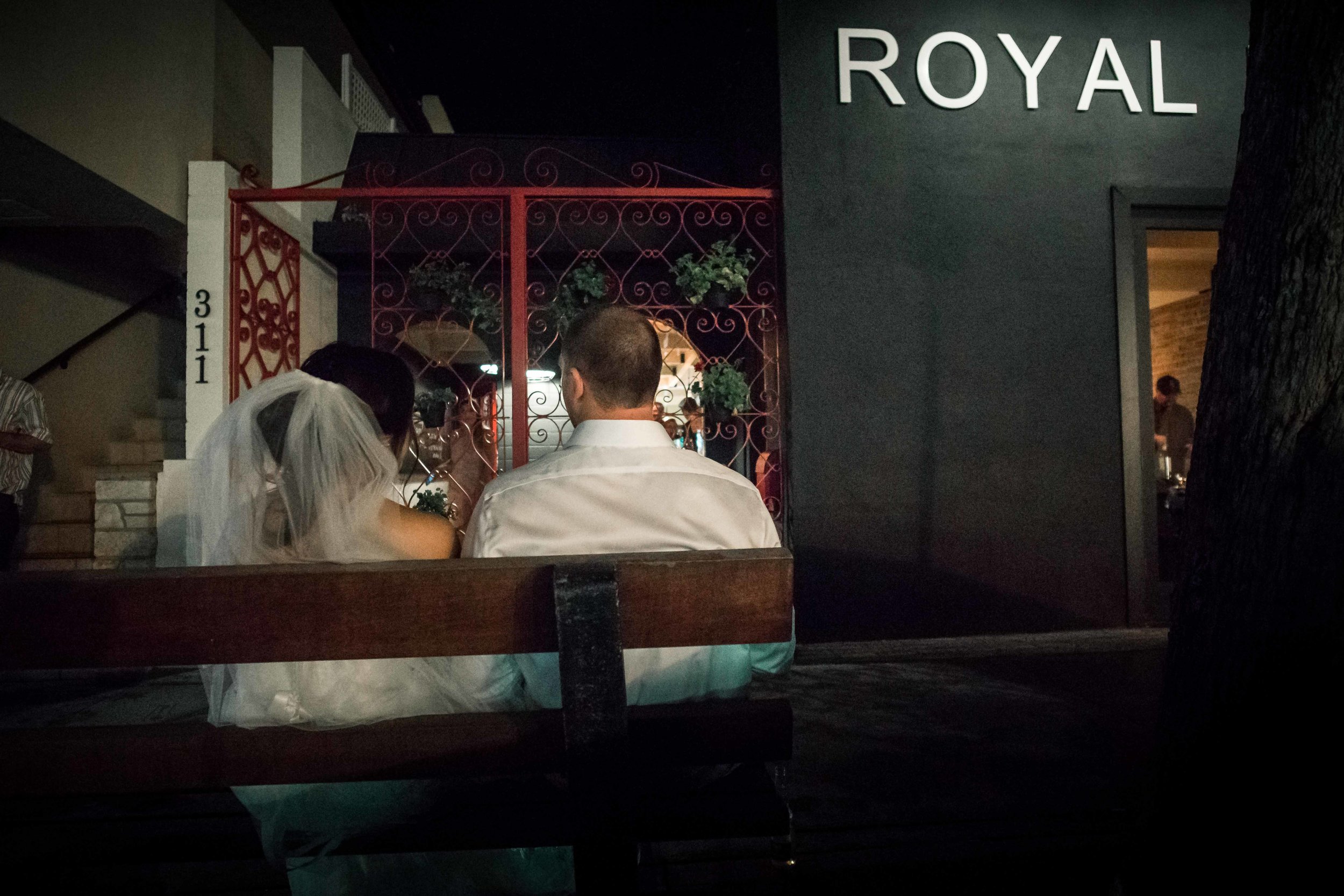 The bride and groom sitting outside of the Royal hand restaurant on Balboa Island