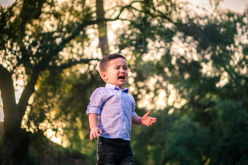 Portrait of a cute little boy crying during a family portrait session in fullerton orange county taken by joseph barber photography