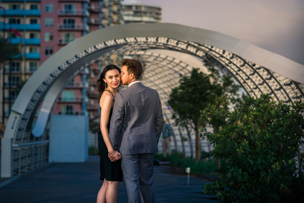 Photo couple Walking under the rainbow bridge To Long Beach convention Center During a couples photo shoot