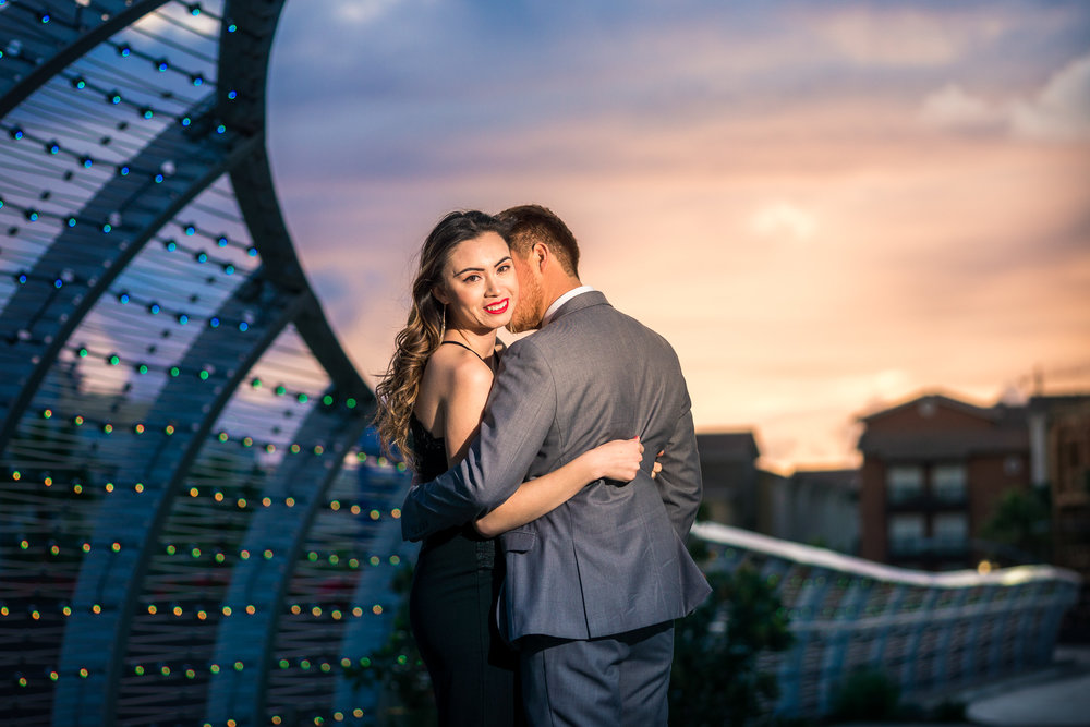 Vibrant and  colorful photo taking a golden hour of a couple embracing at the rainbow Bridge at the Long Beach convention Center