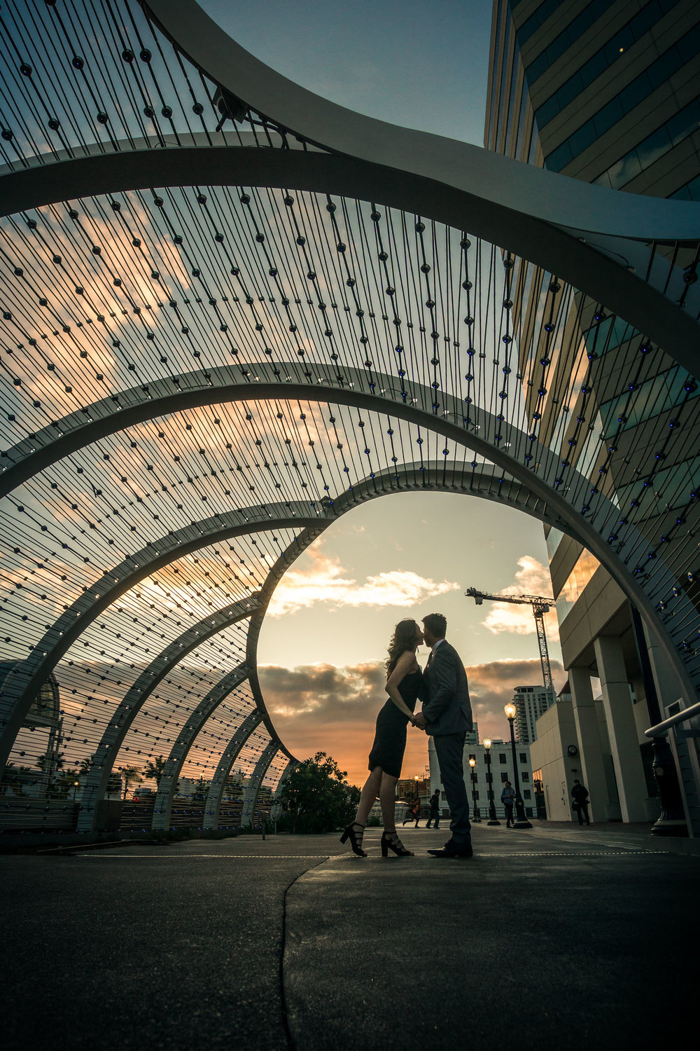 Silhouette of a husband and wife holding hands during a professional portrait photo shoot at the rainbow Bridge At the Long Beach convention Center