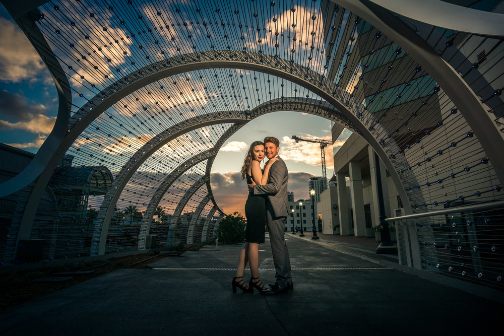 Photo taken at Golden hour of a couple under the rainbow bridge in downtown Long Beach