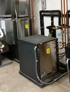 A radiant floor heat pump (foreground) working in conjunction with a forced air heat pump (background)
