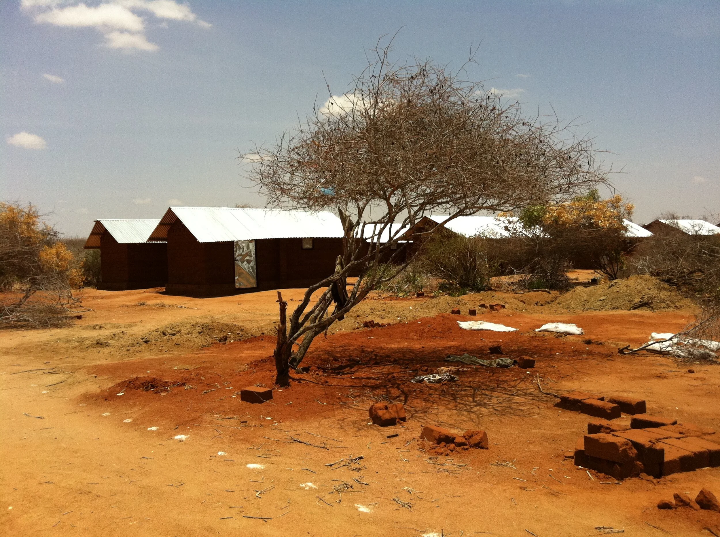 Ifo 2 camp, Dadaab, Kenya. These shelter prototypes were designed and built as part of an international humanitarian initiative to expand a refugee settlement. Before the camp was officially populated, they were among the structures the police used …