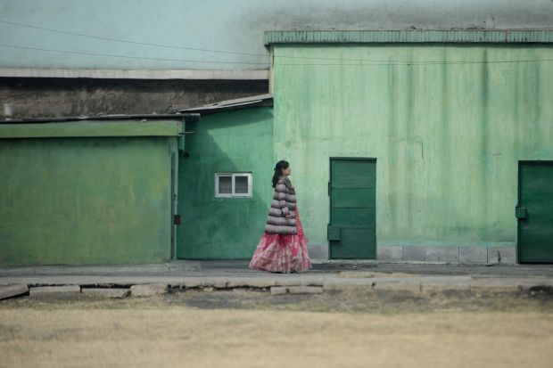 A woman wearing a traditional dress walks along a street in Pyongyang, North Korea, in March.