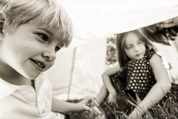 Boy and girl playing under a tent.