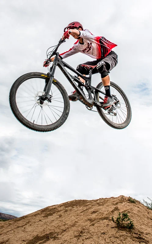 High school senior boy photo flying through air on mountain bike