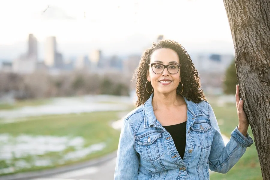 Casual photo of Cherri McKinney wearing a denim jacket and with the city skyline in background