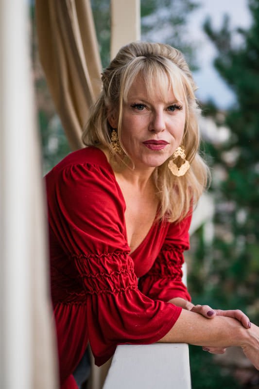 Headshot for dating site, woman in red dress on a porch