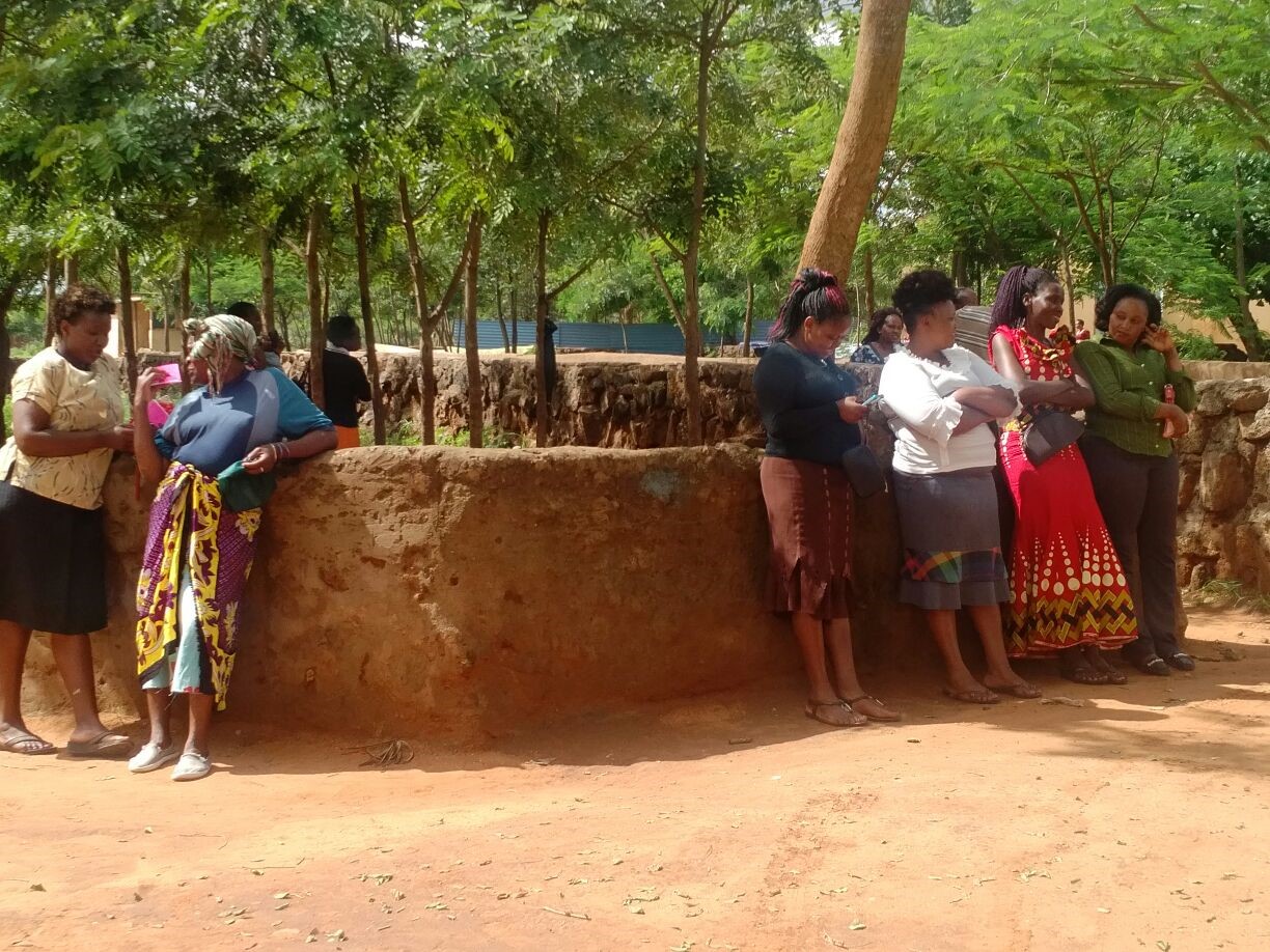 Members of the iMlango community in Makueni County wait to have their application reviewed