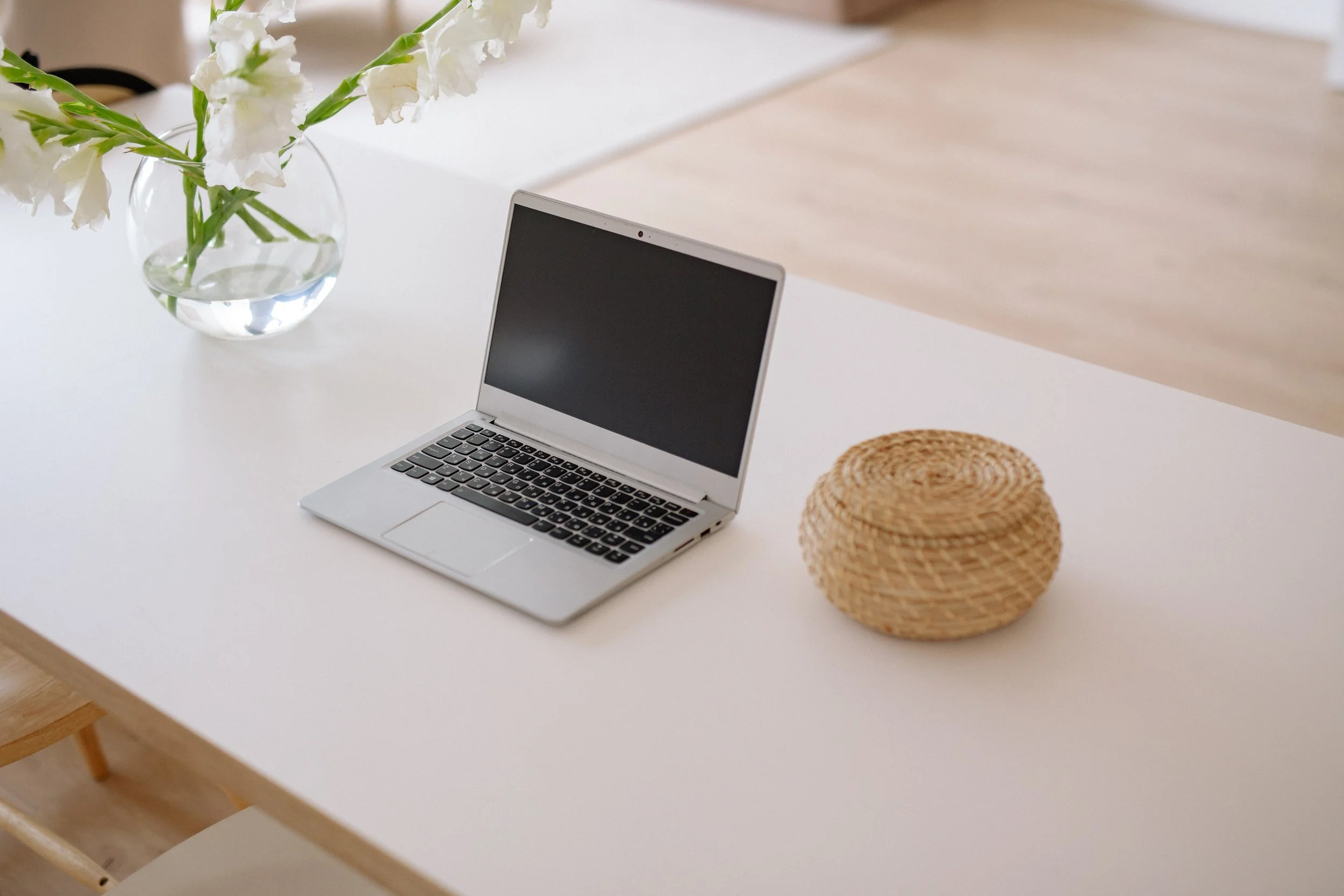 desk with vase of flowers and computer