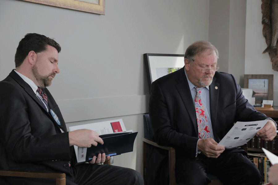 Sen. Tom Bakk (DFL-Cook) (right) studies housing industry priorities during a meeting with constituents.