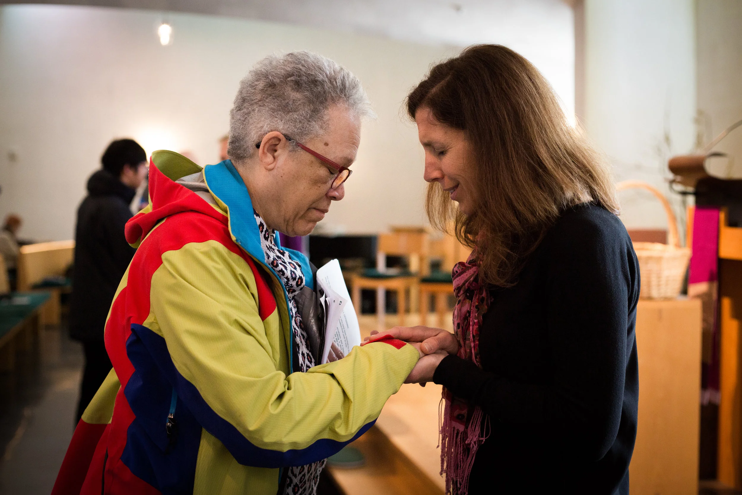 A prayer partner prays with a retreatant after the liturgy, a custom of the Novena.