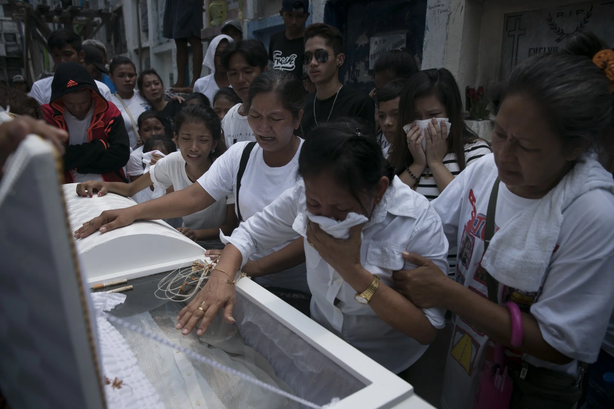 A family weeps at the cemetery as they prepare to bury the casket. Photo: Ed Ou