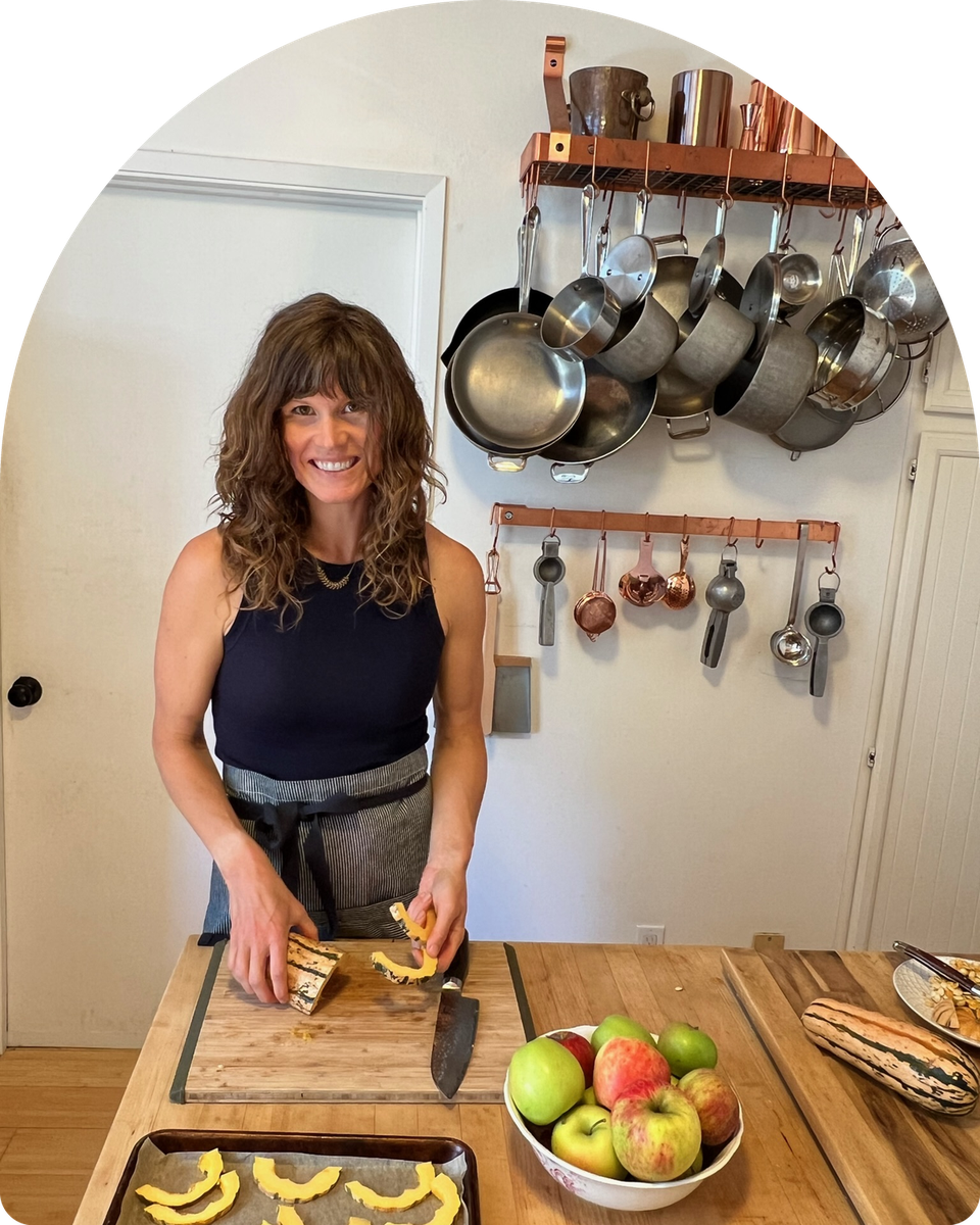 Jeanne Norsworthy, nutritionist and private chef, slicing squash in a kitchen.