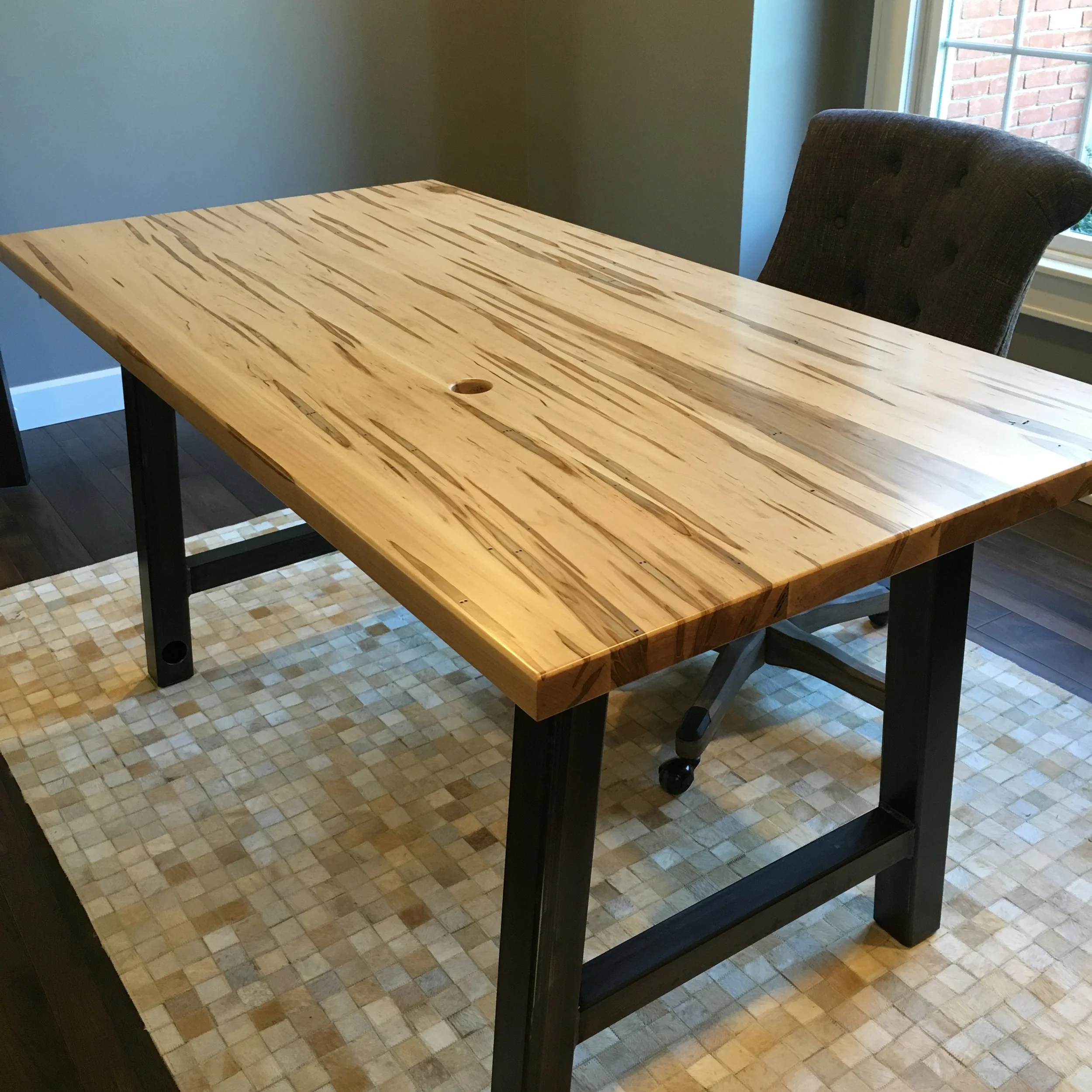  With shades of brown and gray streaking throughout, ambrosia maple is sure to make a statement.&nbsp; And the steel legs of the desk compliment the wood well. 