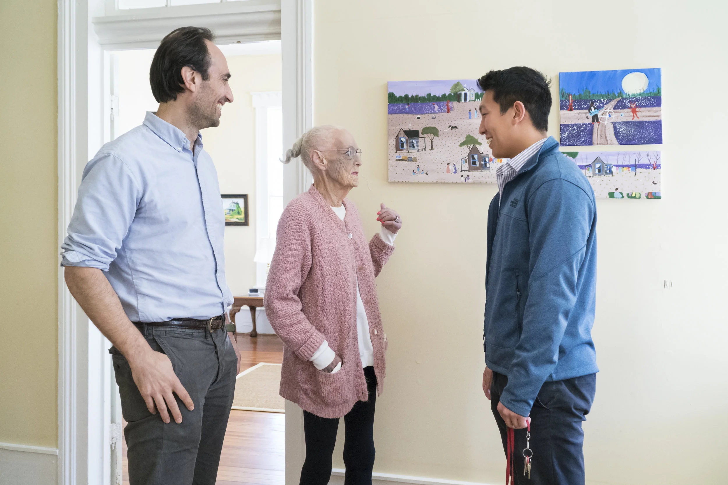 Dr. Dorsey and Kevin Wang, 2017-18 Fellow, speaking with one of the housing program residents.