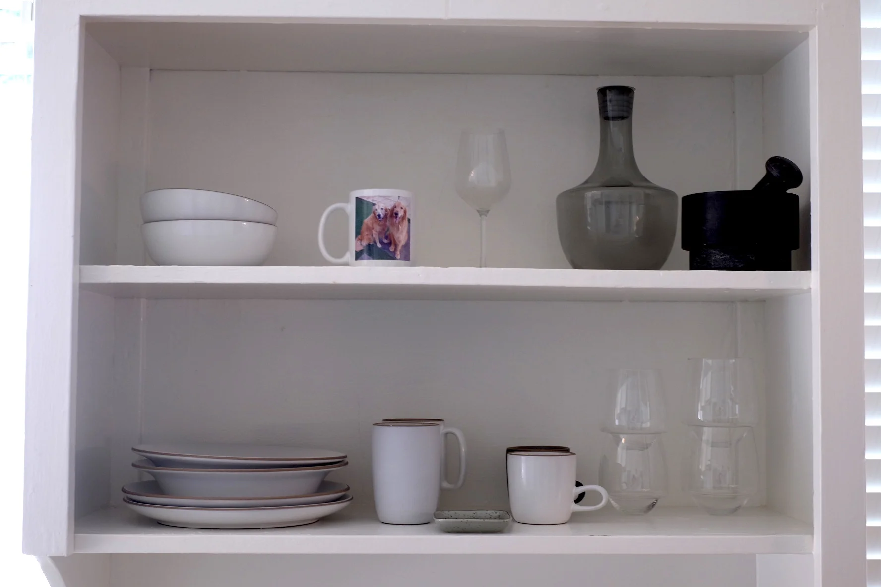 My tableware shelf: Heath plates and bowls, SDS Saturn Glasses (red wine and white wine), an Ikea wine glass I use as a tea light holder, a water pitcher (also Ikea), a mortar and pestle, a sauce dish given to me by my friend Benny, and a mug with a picture of my dogs