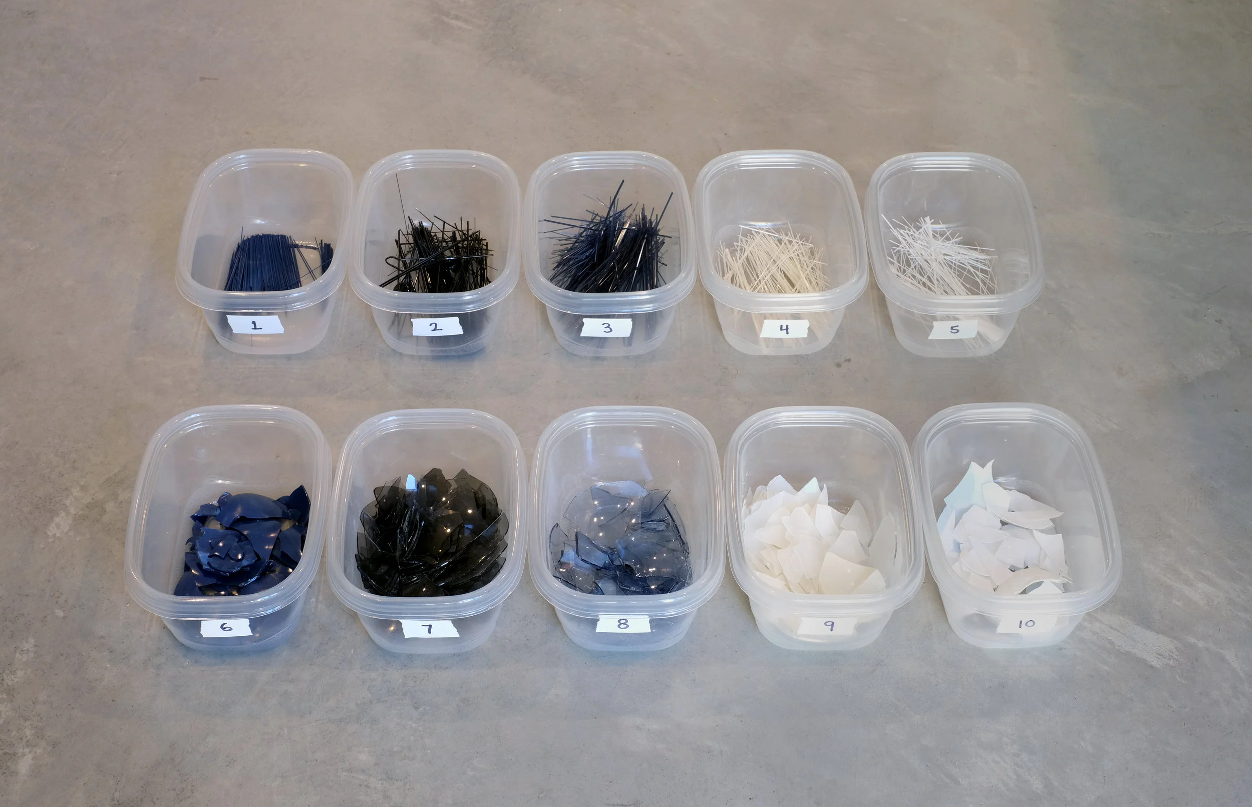 Numbered bins of colored glass strings and shards