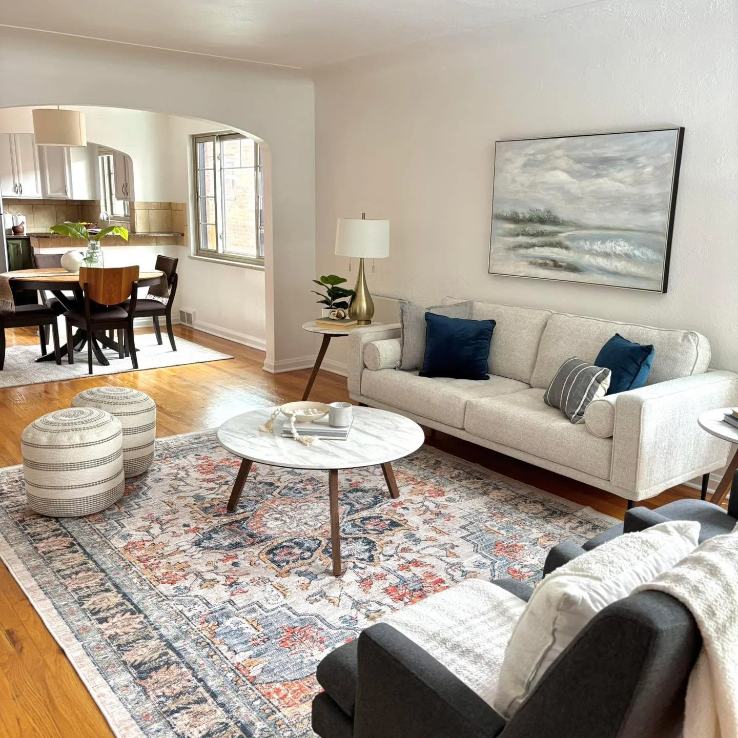 Classic charm meets modern comfort ✨ This beautifully staged space highlights the home&rsquo;s natural light, warm hardwood floors, and timeless architectural details. Soft neutral furnishings paired with rich navy accents create an inviting atmosphe