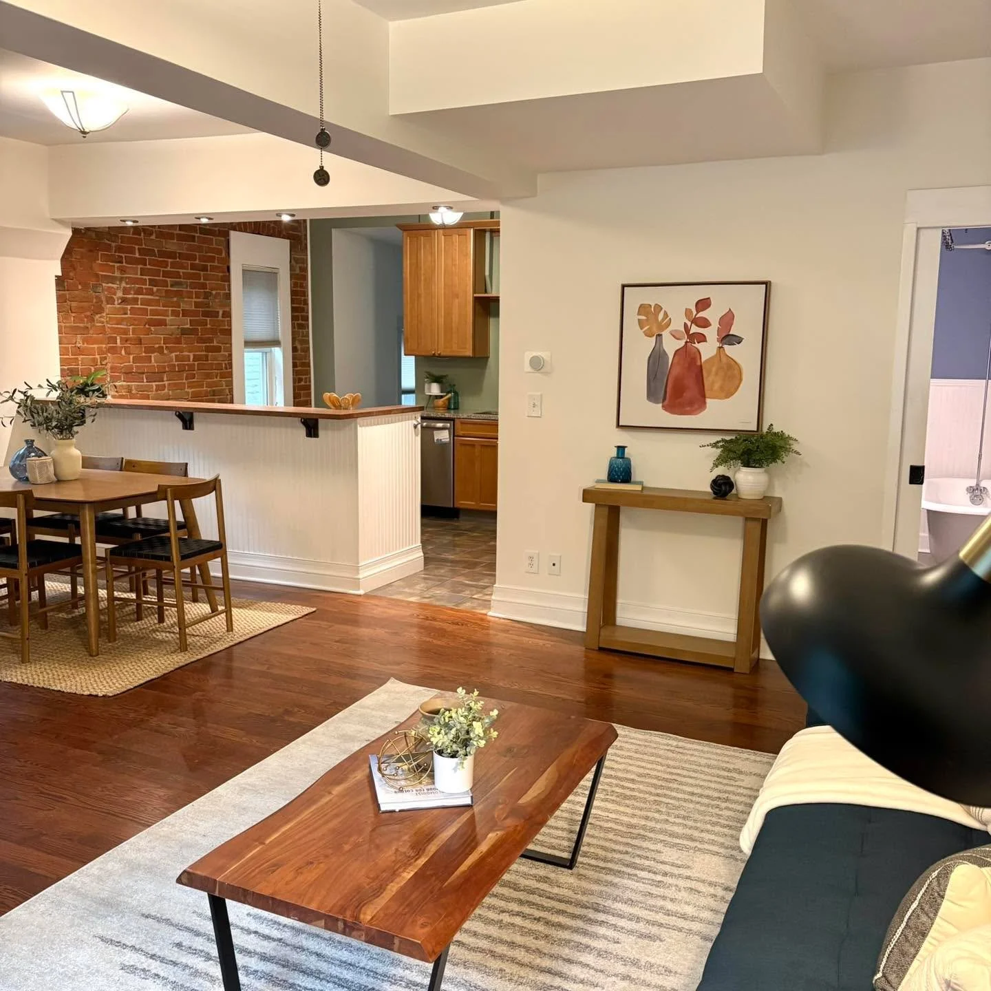 Warm wood tones, exposed brick, and an open-concept layout make this home feel both timeless and inviting ✨ From the rich hardwood floors to the cozy dining nook and modern staged accents, every detail was designed to highlight the home&rsquo;s chara