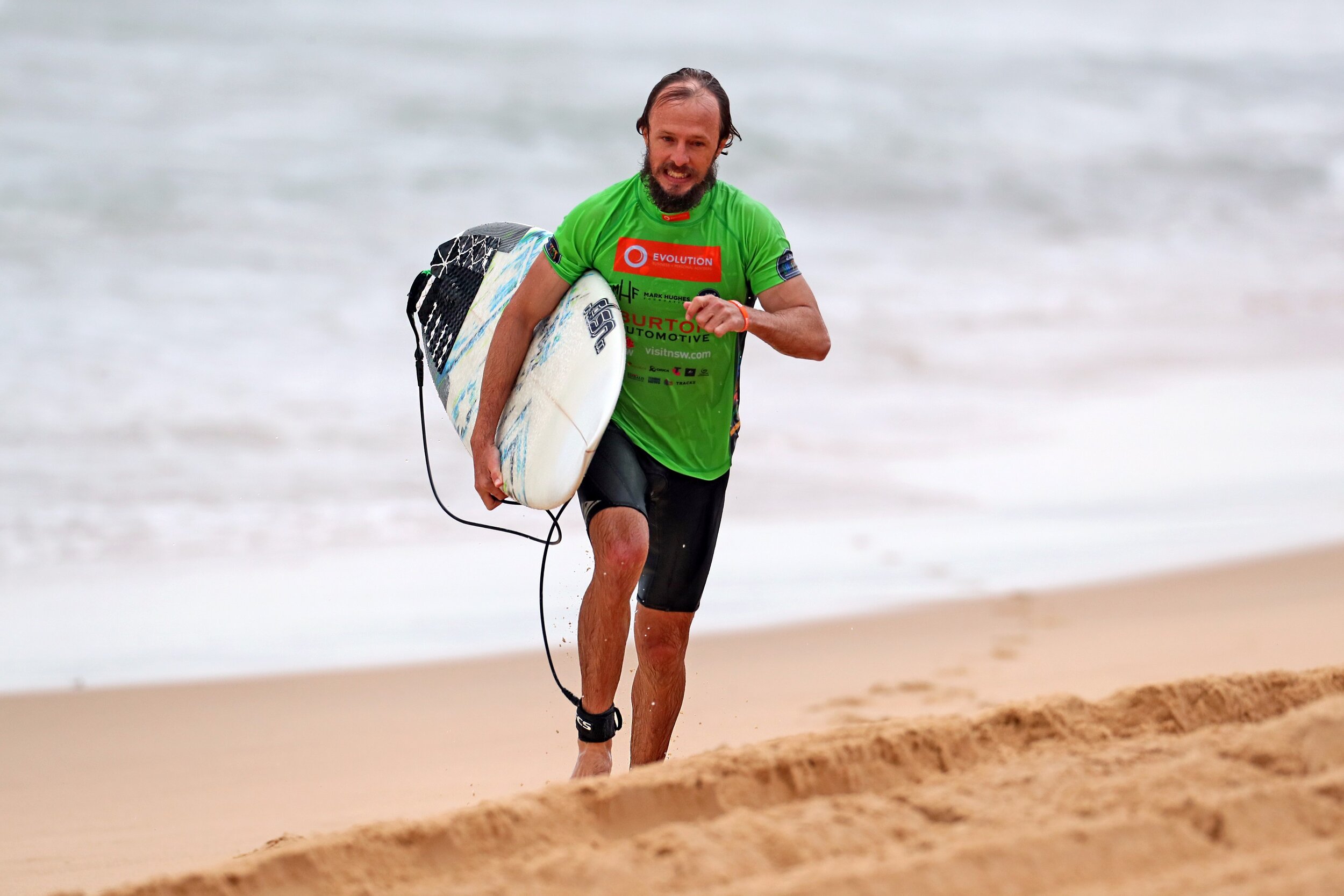 green surfer running up beach.jpg