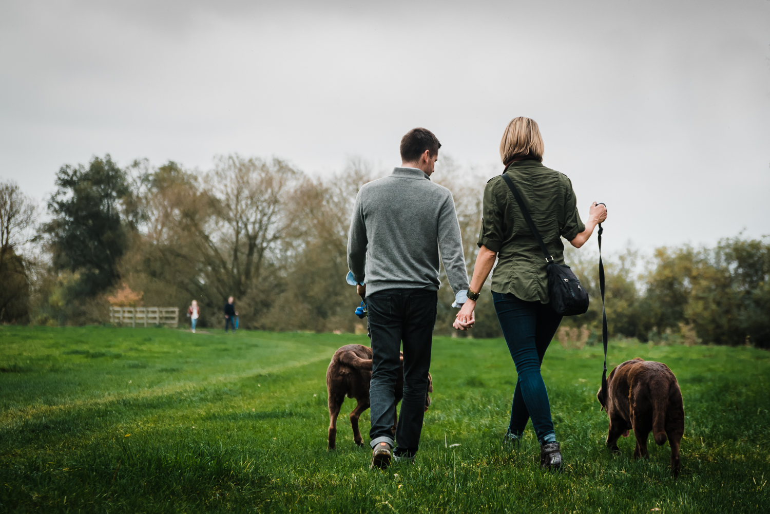  Couple holding hands on a walk in Grantchester Meadows 