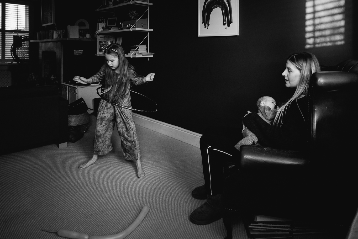 mother watching daughter hula hooping in lounge