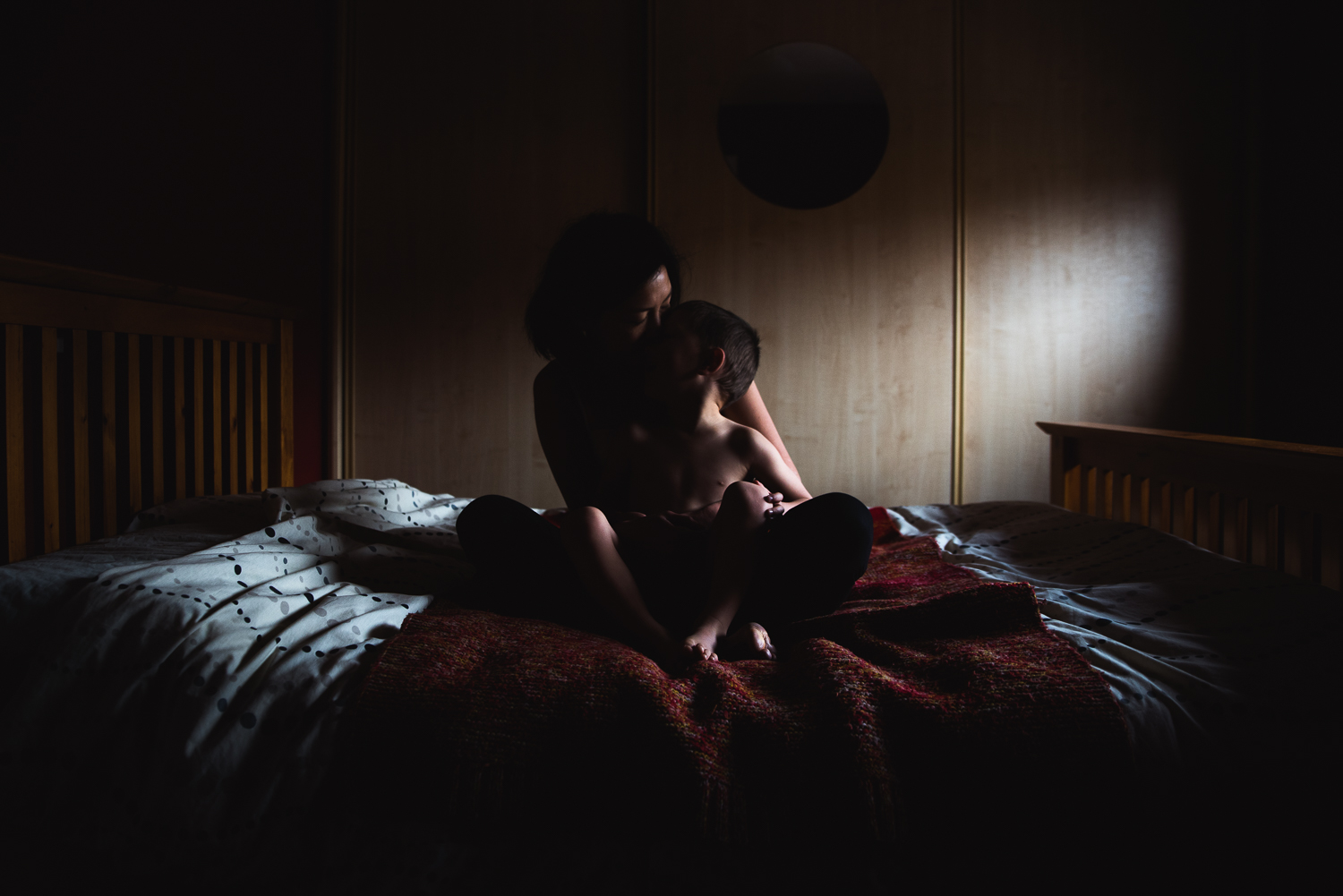 mother and son portrait moody image in shadows