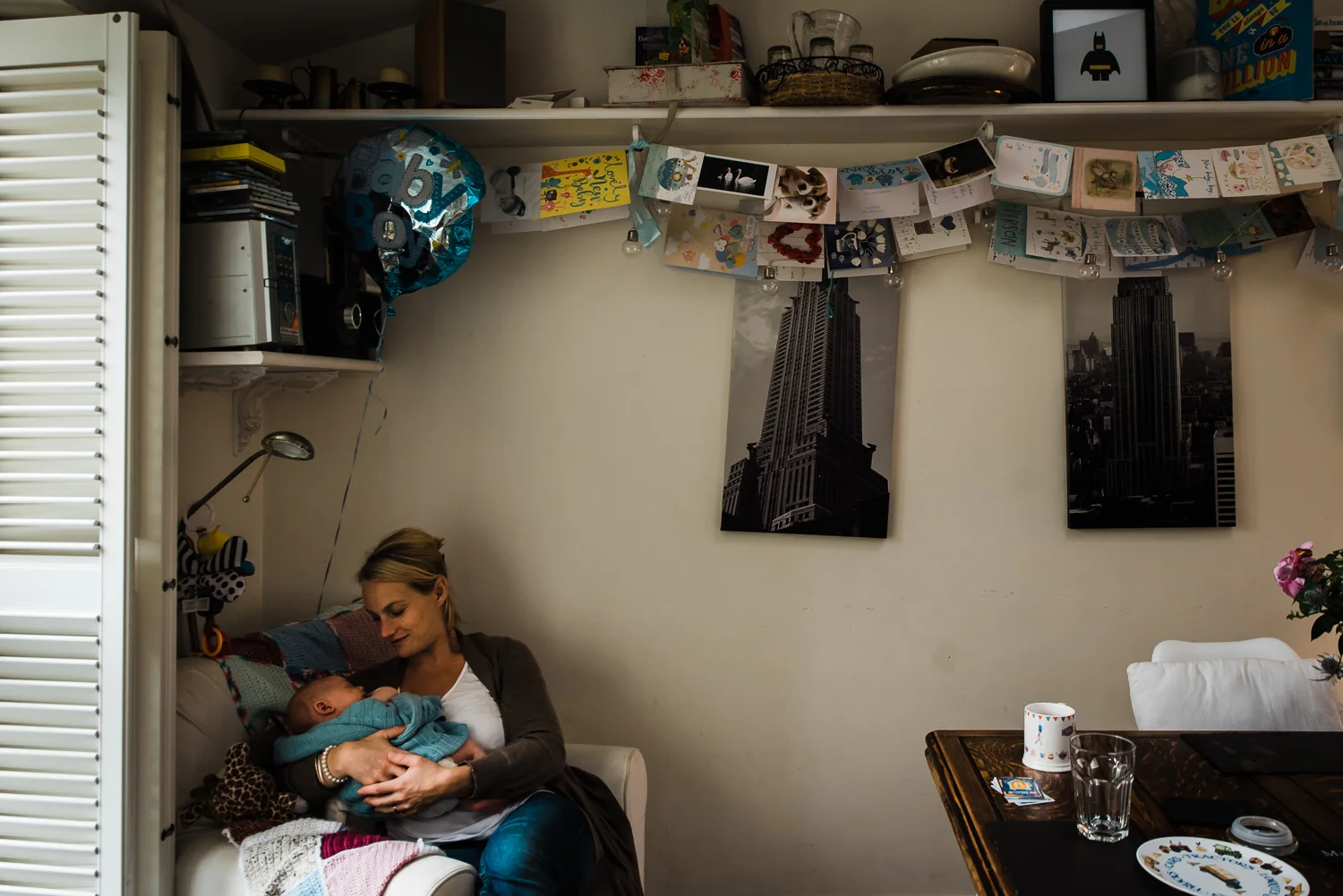 mother cradles newborn baby in-home lifestyle documentary session