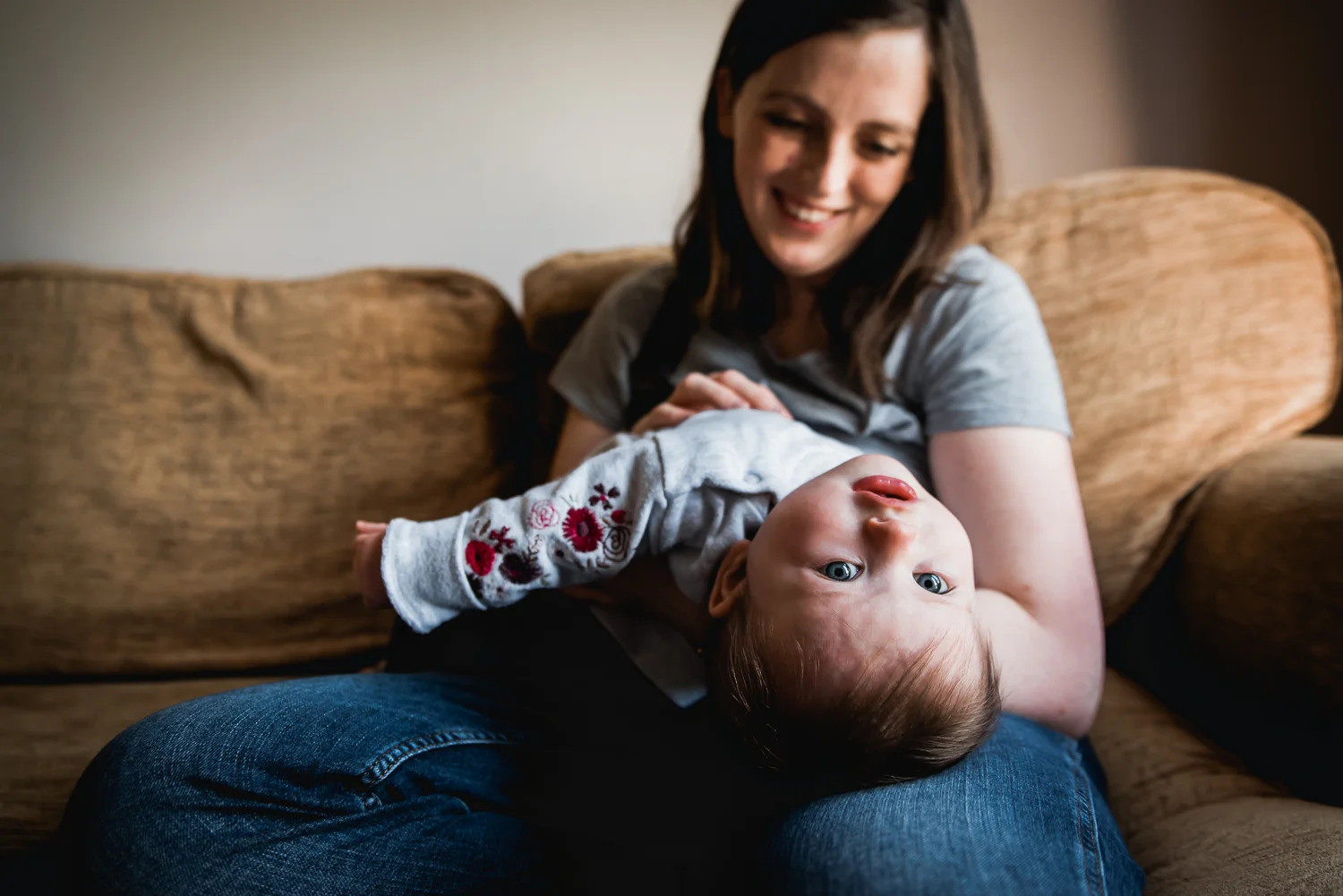 baby upside-down in mother's arm