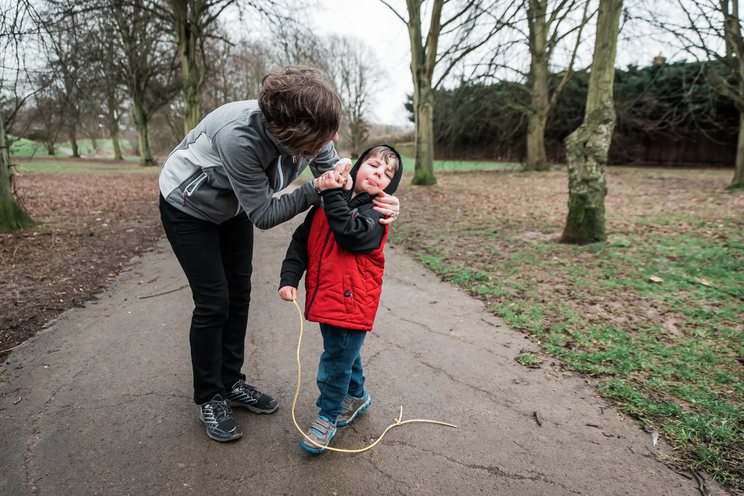 Copy of Mother wiping her boys nose in the park