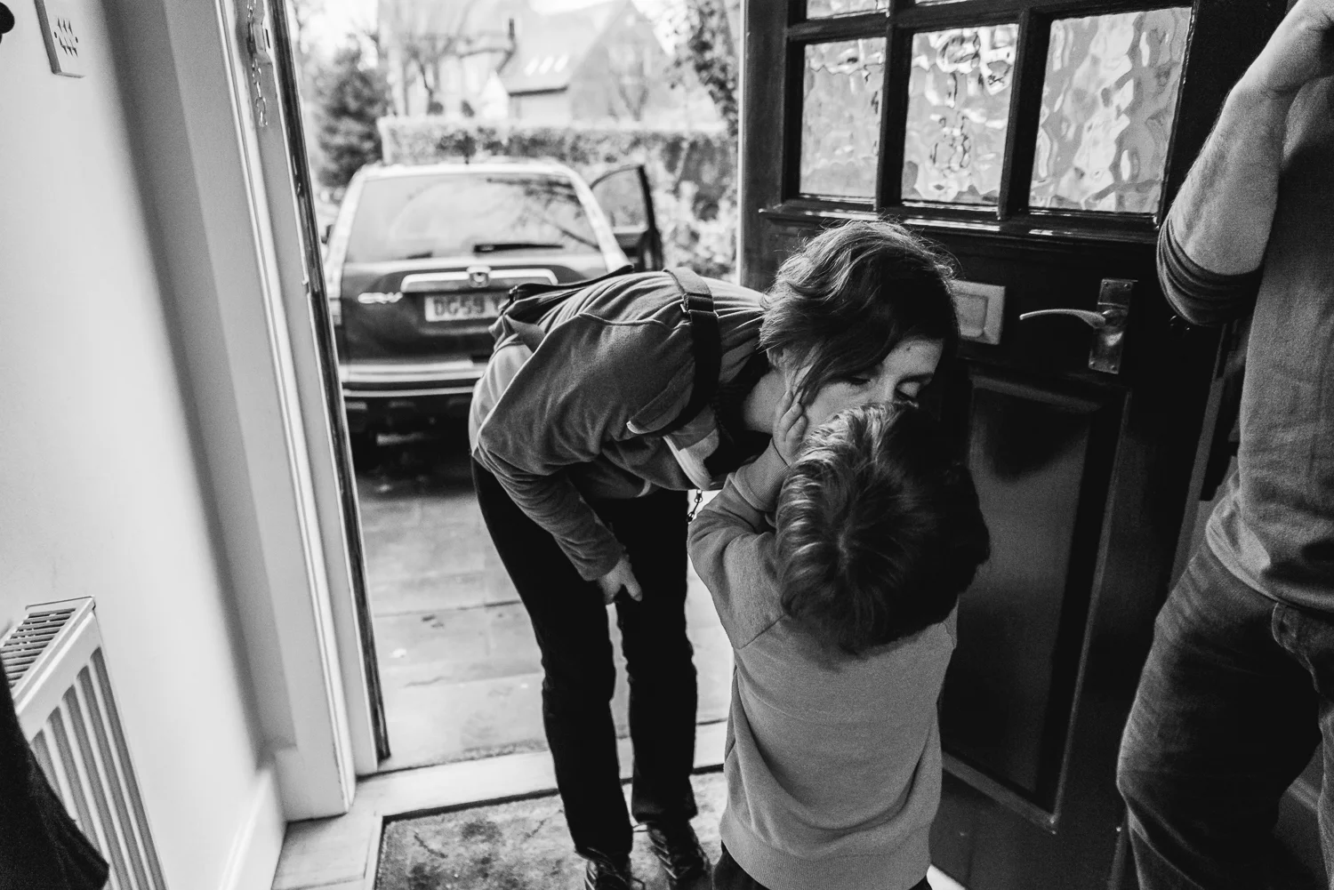 Copy of Son giving his mother a kiss goodbye at the door - Diana Hagues
