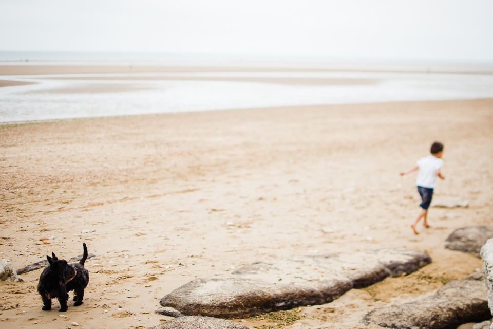 Freelensed photograph of young boy and his dog on the beach on t