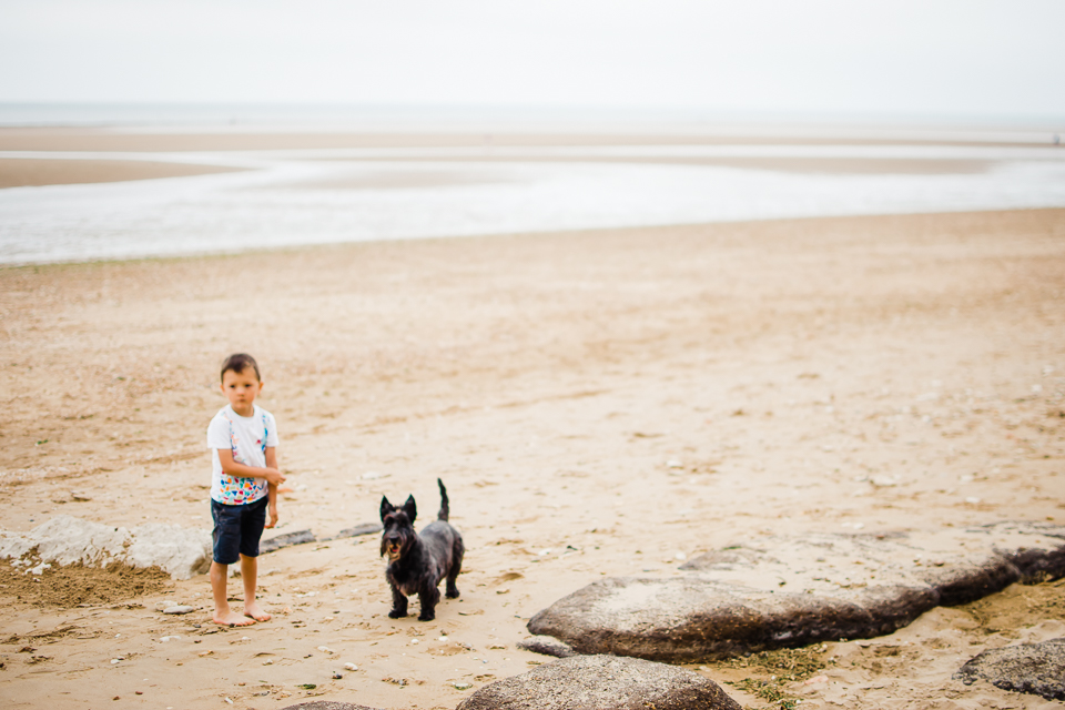 Freelensed portrait of young boy and his dog on the beach on the